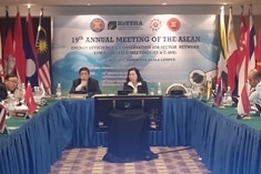 People sit around a large conference table at the 19th Annual Meeting of the ASEAN, with national flags and a presentation screen in a formal setting.