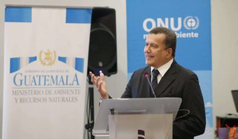 A man in a suit speaks at a podium with Guatemala Ministry of Environment and UN Environment banners in the background.